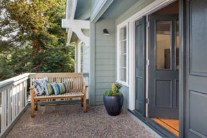 Entrance porch decorated with antique bench, big flower pot 