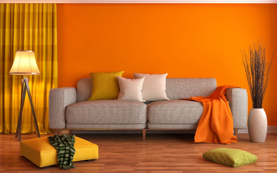 Orange wall with gray couch
