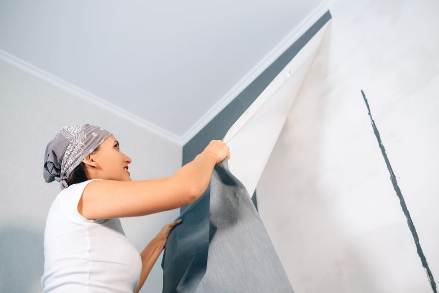 woman removing wallpaper